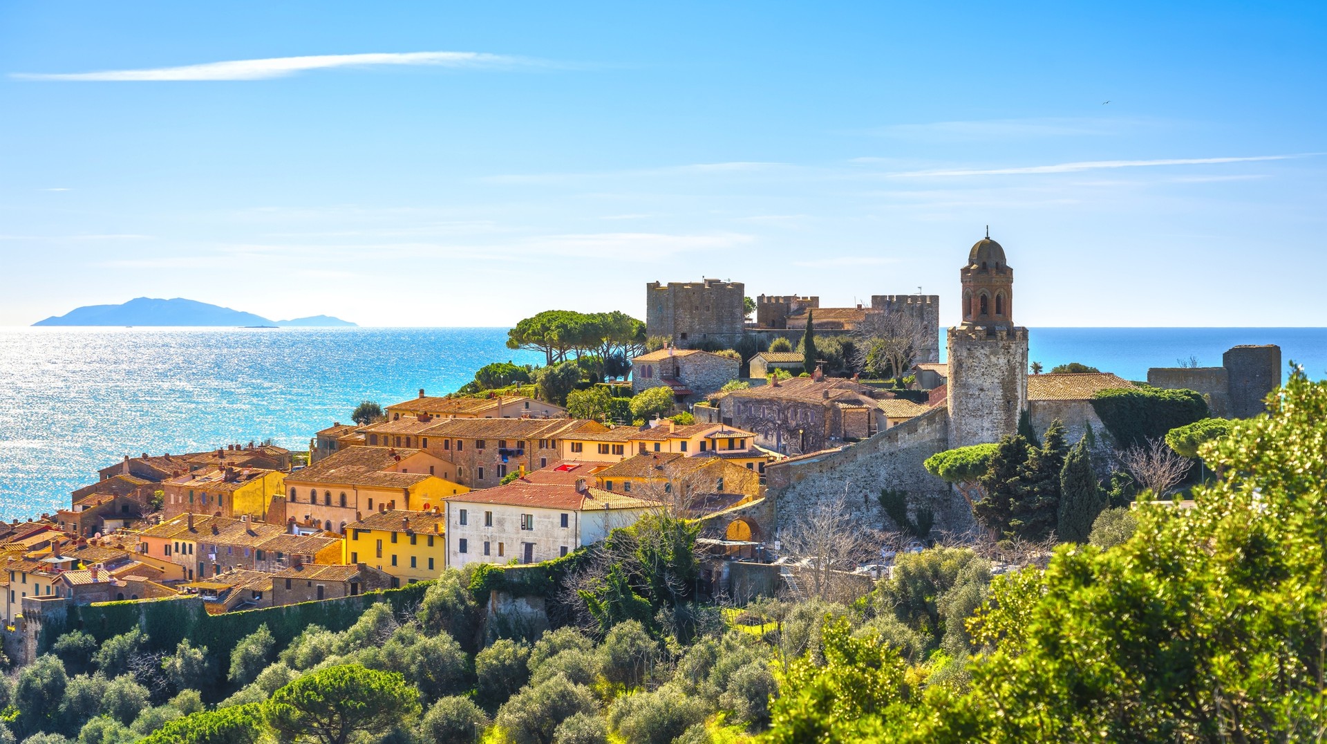 Enjoy the spectacular view of an old town and the sea in Castiglione della Pescaia, Italy. View of Castiglione della Pescaia, an old town in Tuscany in Italy in May.
