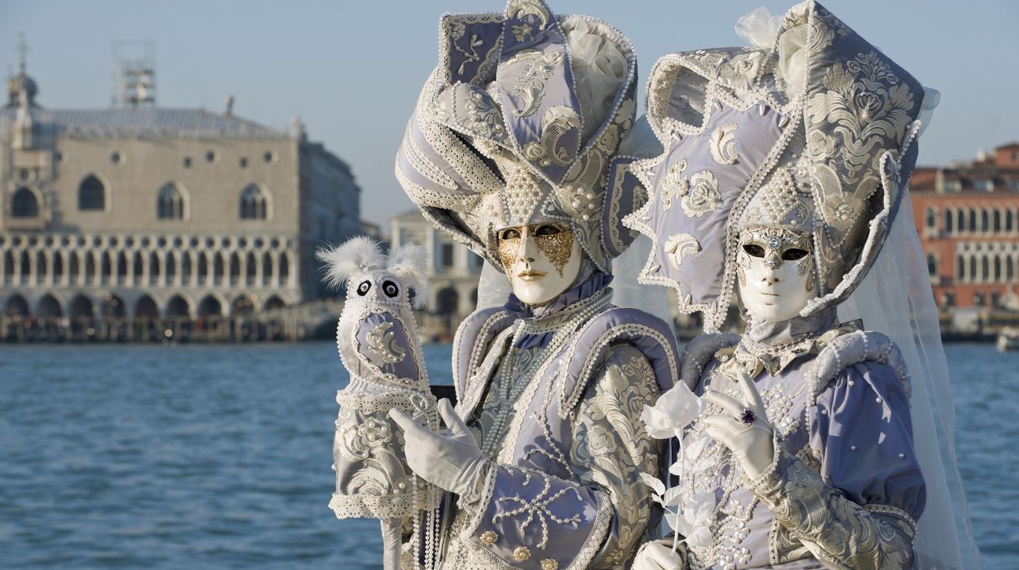 Couples in mask in front of Saint Mark square on Venice, Italy in winter.