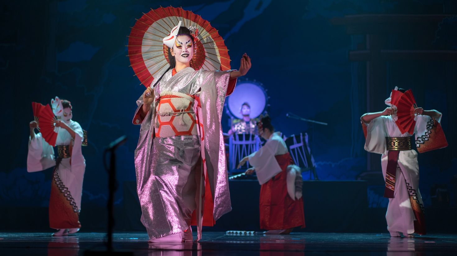 Actresses in traditional kimono and fox mask dancing with umbrella and fans