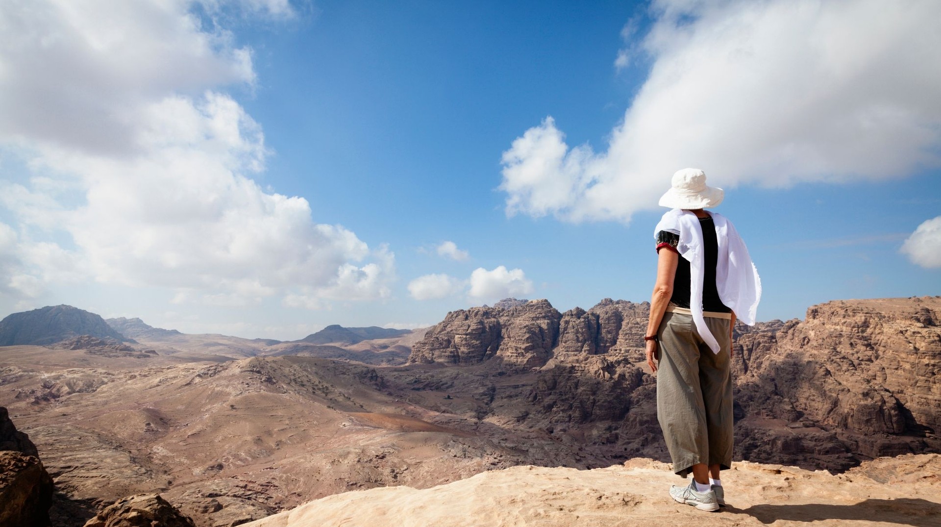 A woman admiring the view of the Jordanian desert while hiking in Petra during her 2 weeks in Jordan.