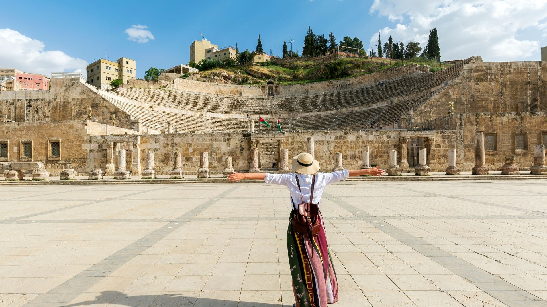 A young girl with open arms in Roman Theatre during her 6 days in Jordan.