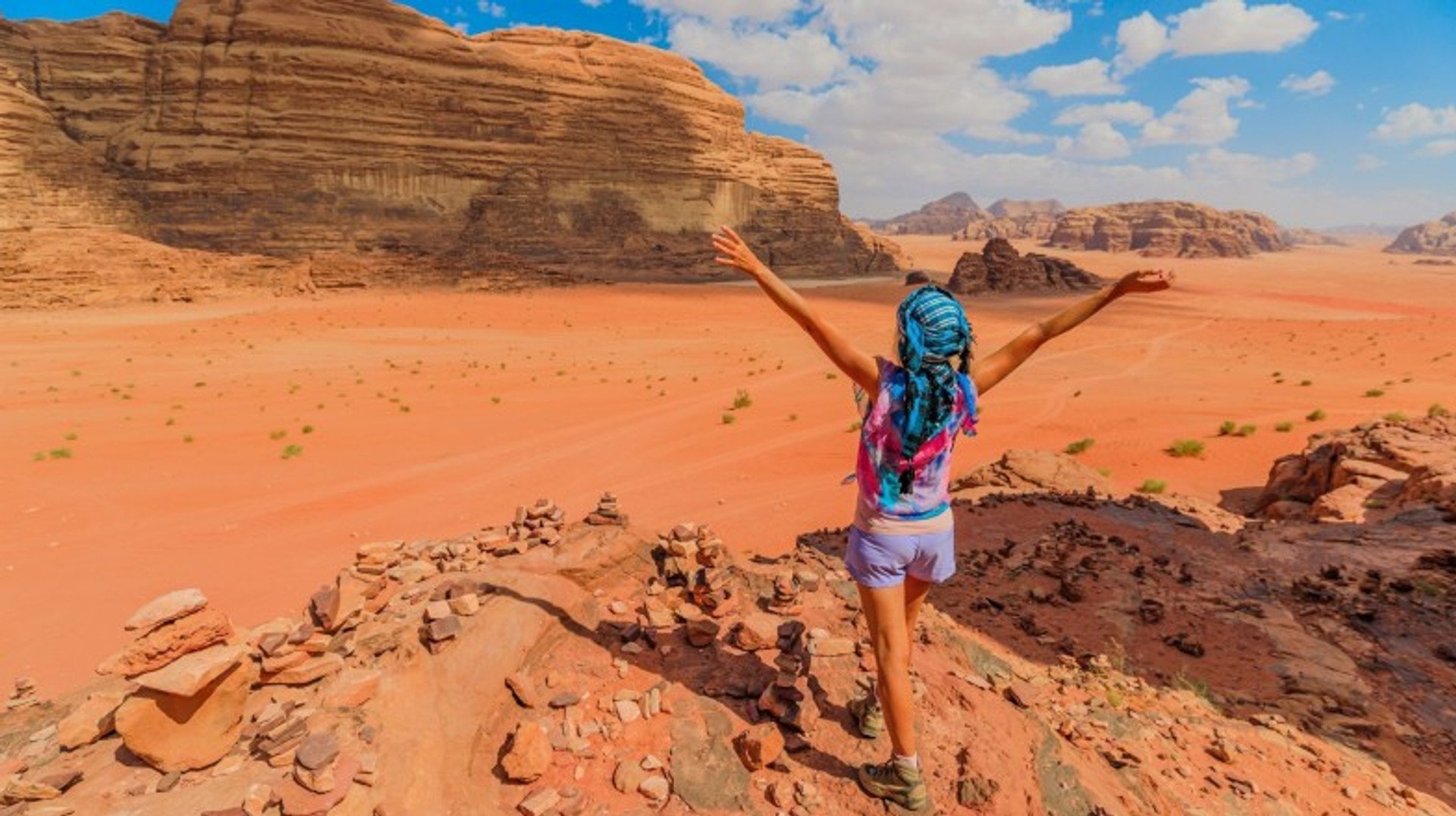 A girl with open arms in Wadi Rum during her 9 days in Jordan.