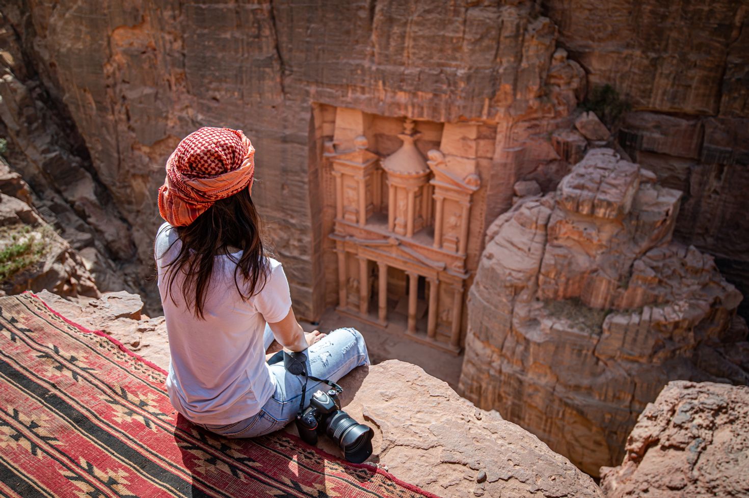 A tourist relaxing and enjoying the magnificence of Petra in Jordan.