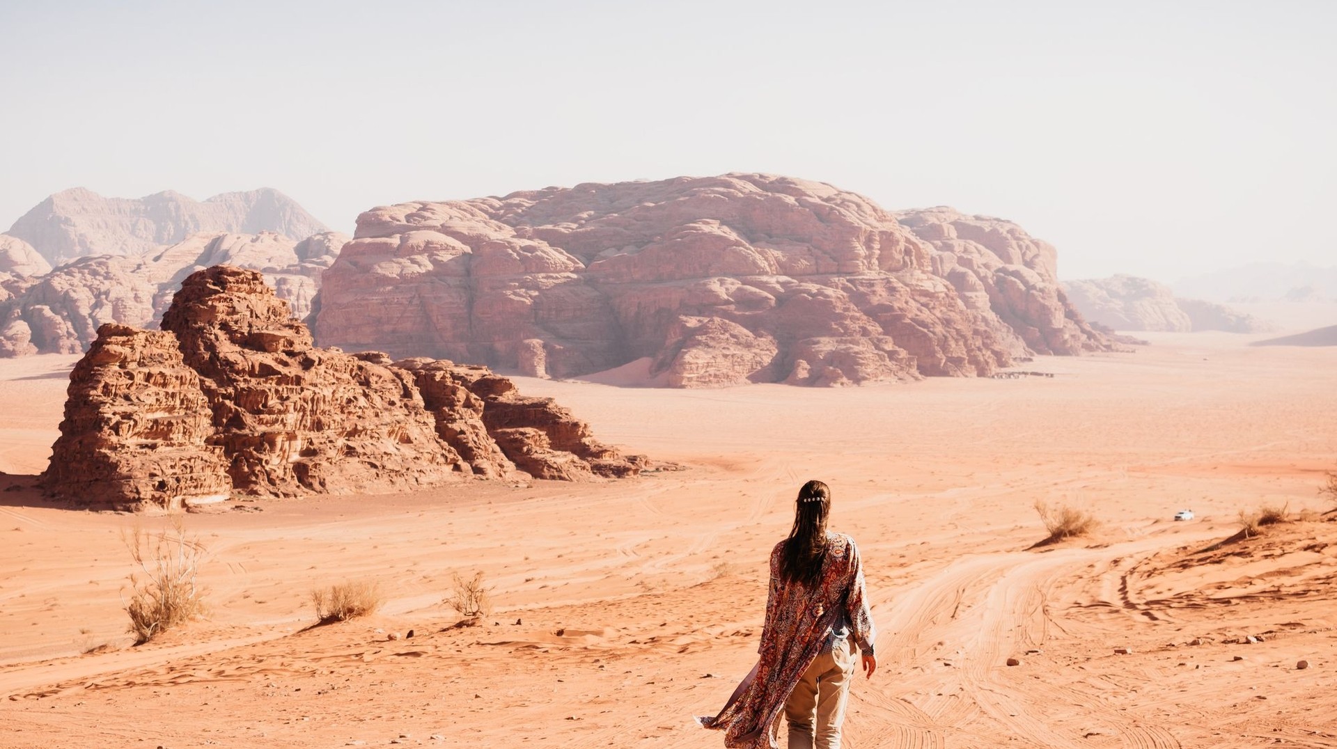 Discover the beauty of Wadi Rum in Jordan in September, with cooler weather ideal for exploring its stunning desert landscapes. A woman walking in Wadi Rum in Jordan in September.