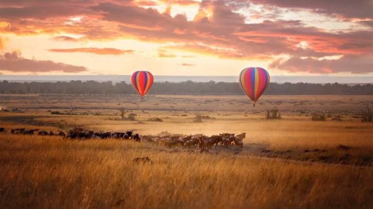 Hot air balloons rise in Maasai Mara during sunrise in Kenya in 4 days.