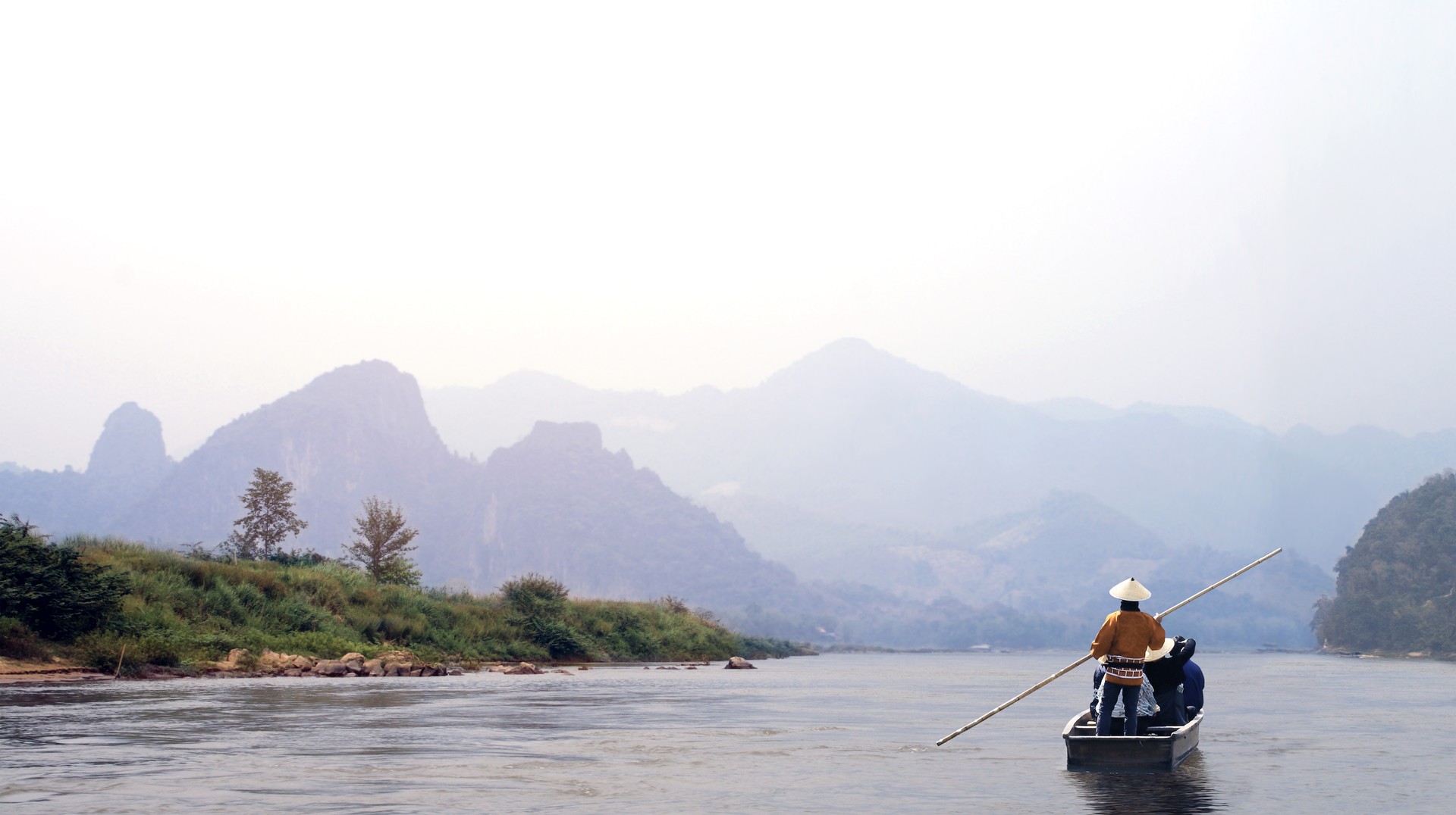 Sail along the famous Mekong River during your 6 days in Laos. A man rows his boat along the Mekong River in Laos.