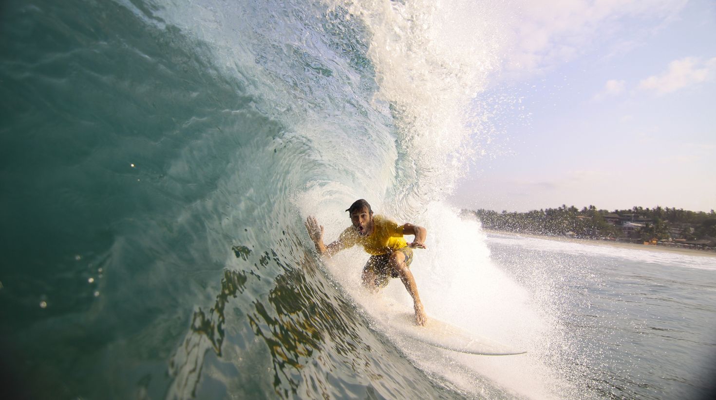 Surfer making his way into a blue water barrel in Mexico.
