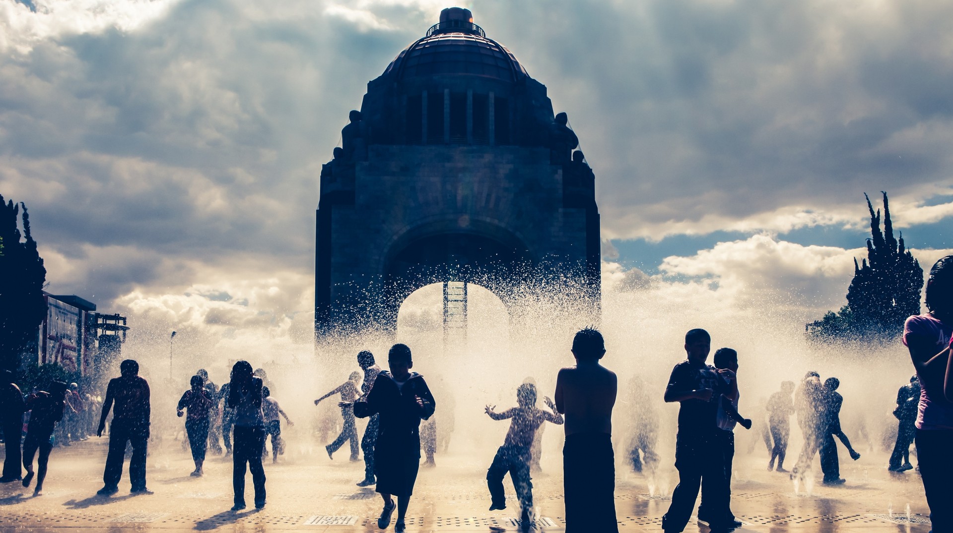 Even though it is monsoon in Mexico in June, the country still offers visitors the opportunity to indulge in its historic and cultural beauty. Kids play in the fountains in the center of city in Mexico in June.