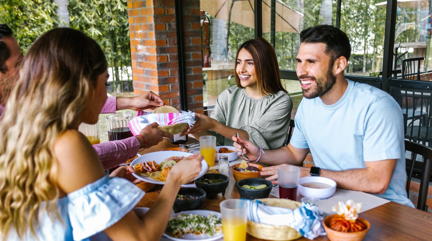 Group of latin friends eating mexican food in the restaurant terrace in Mex