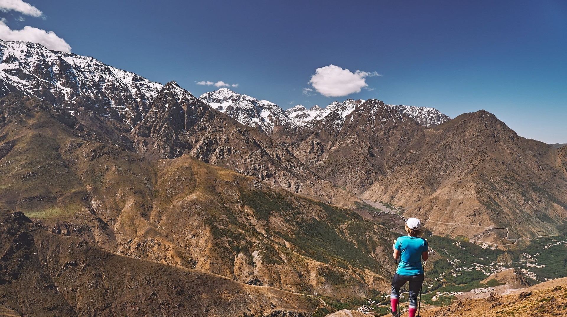 Admire the breathtaking Atlas Mountains during your 12 days in Morocco, where stunning landscapes and vibrant Berber culture await you at every turn. A girl admiring the beauty of Atlas Mountain during her 12 days in Morocco.