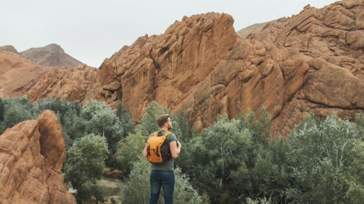 A hiker with his backpack admiring the beauty of Todra Gorge on a clear day