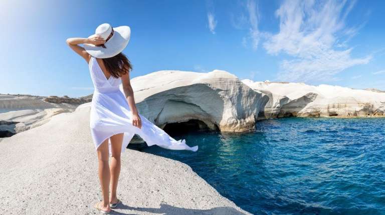 A tourist girl walks in Sarakiniko, on the island of Milos, one of the most famous islands in Greece.