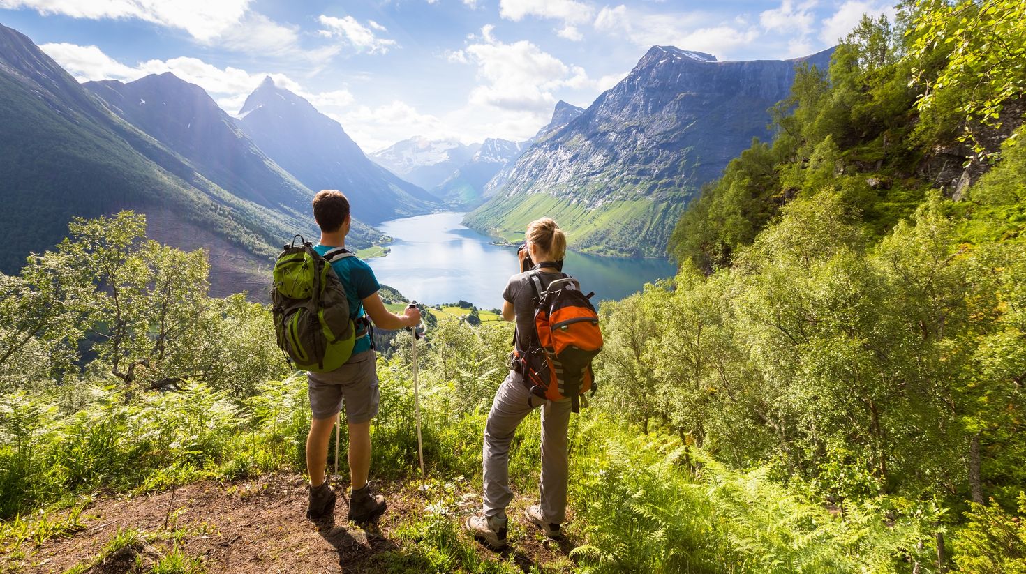 Tourists enjoying beautiful view of valley in warm weather in Norway.