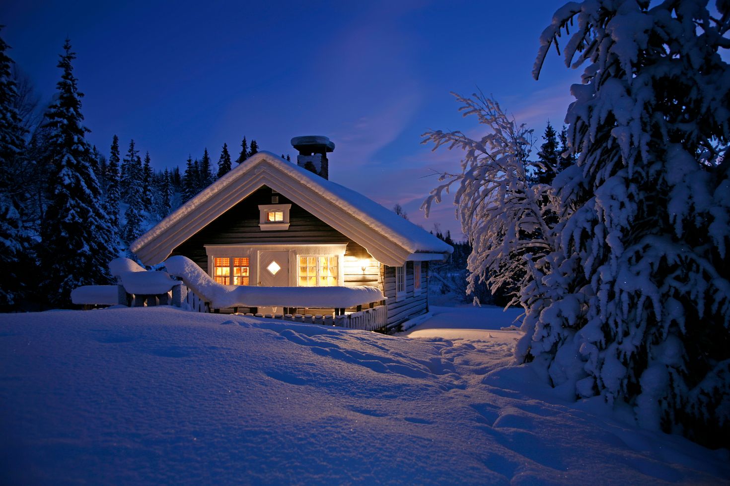 Cottage in Norway covered with snow at nightfall