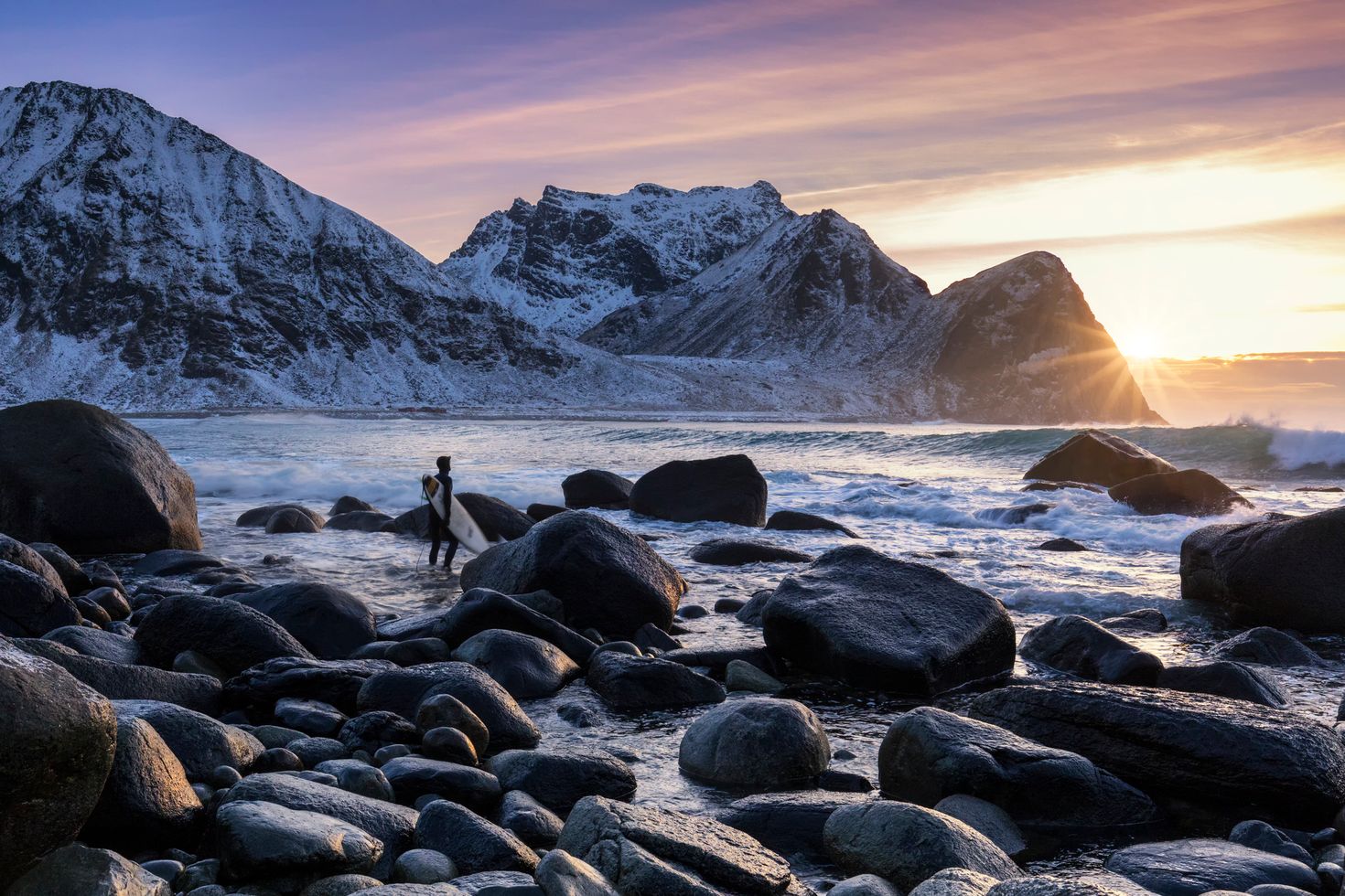 Surfer withstand high waves at Unstad beach in Norway during winter