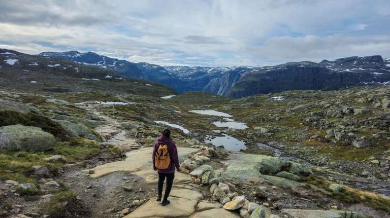 A hiker in the Trolltunga on a cloudy day in Norway in June.
