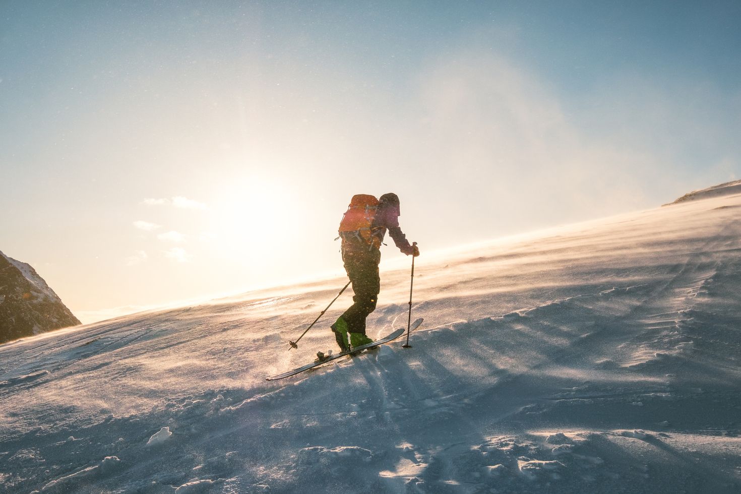 Man trekking on the snow mountain with sunlight and storm