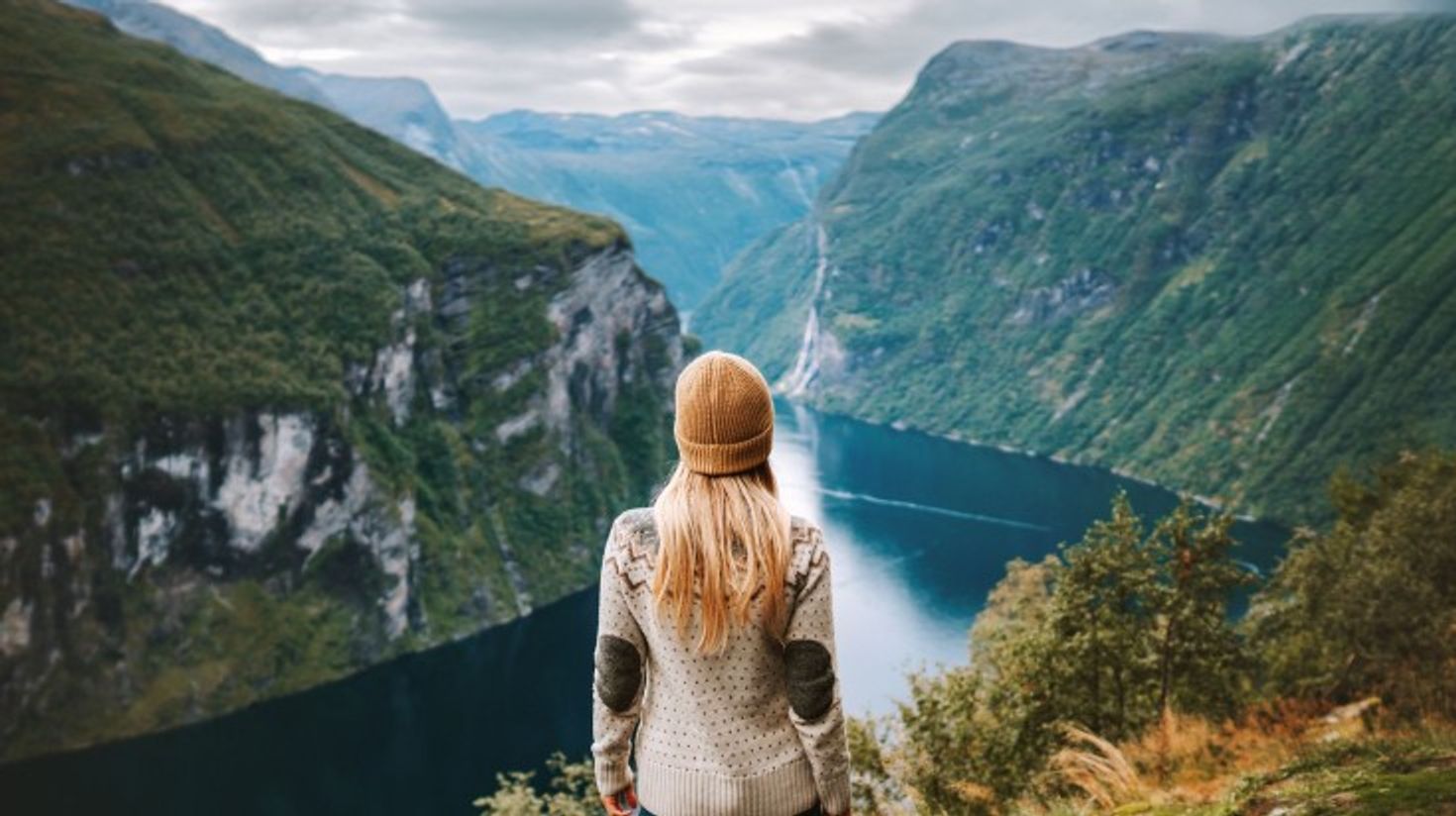 A woman admiring the beauty of Geirangerfjord view during her hike.