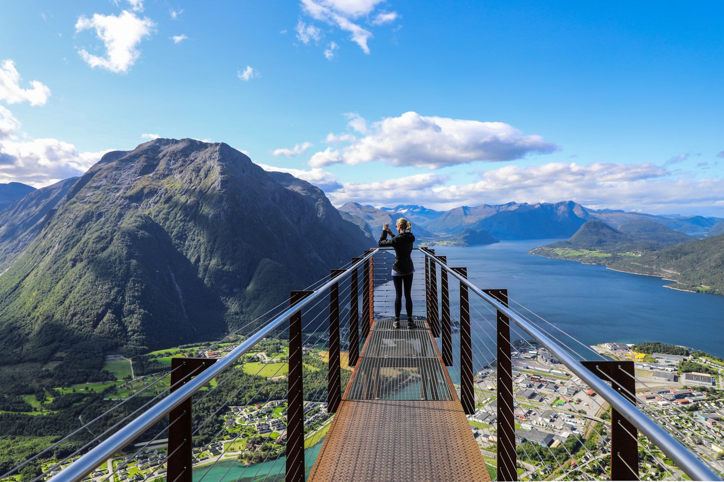 Panoramic view of woman taking photo of Andalsnes on a platform at the top