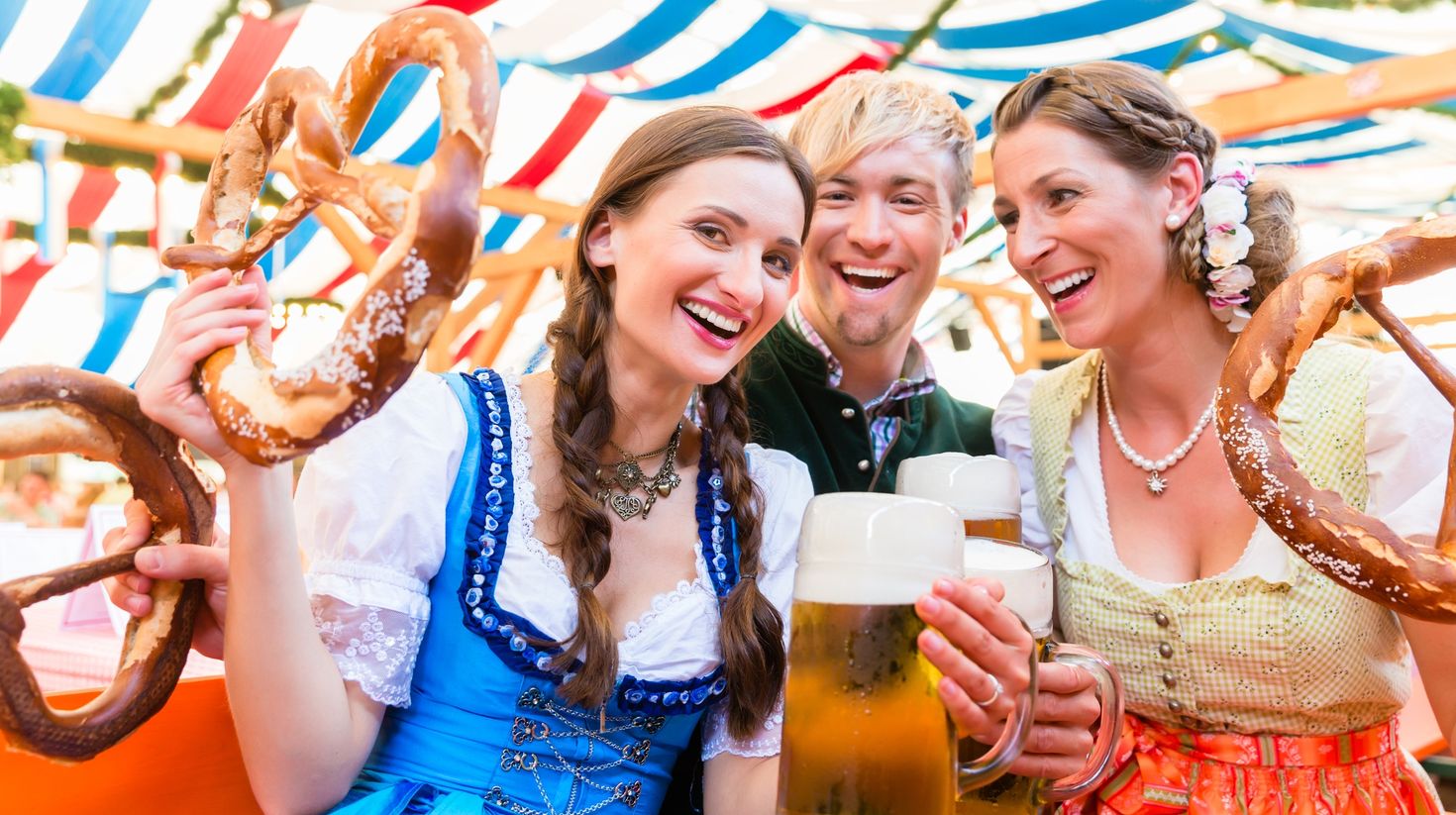 Friends with giant pretzel and beers during Oktoberfest