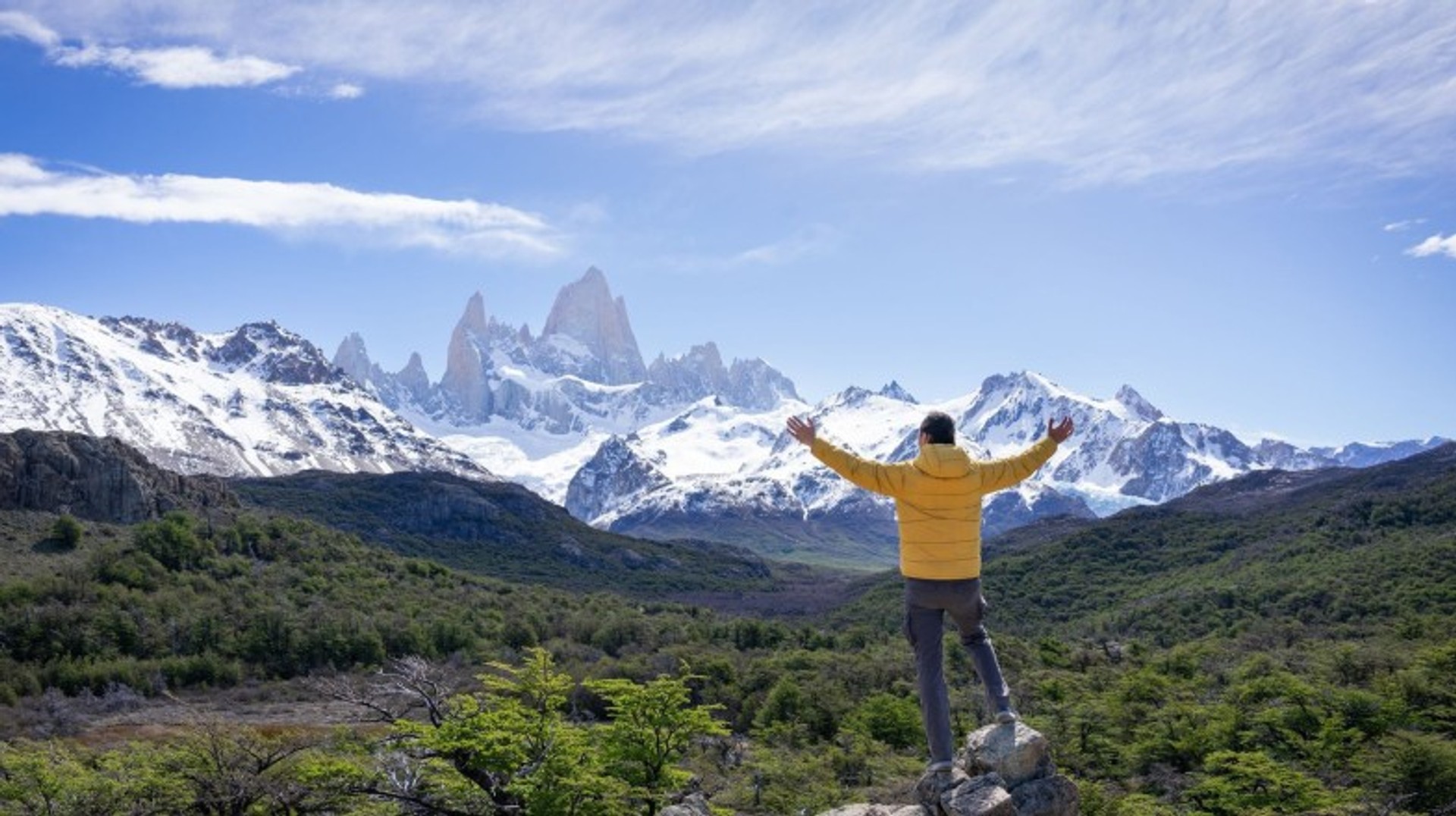Explore the breathtaking Mount Fitz Roy during your 12 days in Patagonia and immerse yourself in its stunning beauty A man with open arms in front of Mount Fitz Roy during his 12 days in Patagonia.
