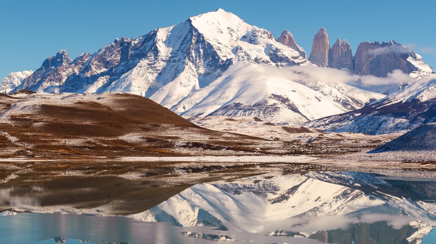 Torres del Paine Andes peaks in winter reflection in Patagonia during July.