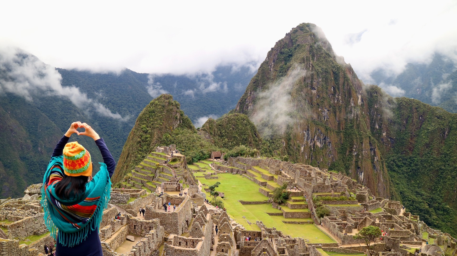 Experience the awe-inspiring wonders of Machu Picchu within your 5 days in Peru, immersing yourself in ancient history, stunning landscapes, and vibrant culture. A woman posing in front of Machu Picchu on her trip of 5 days in Peru.