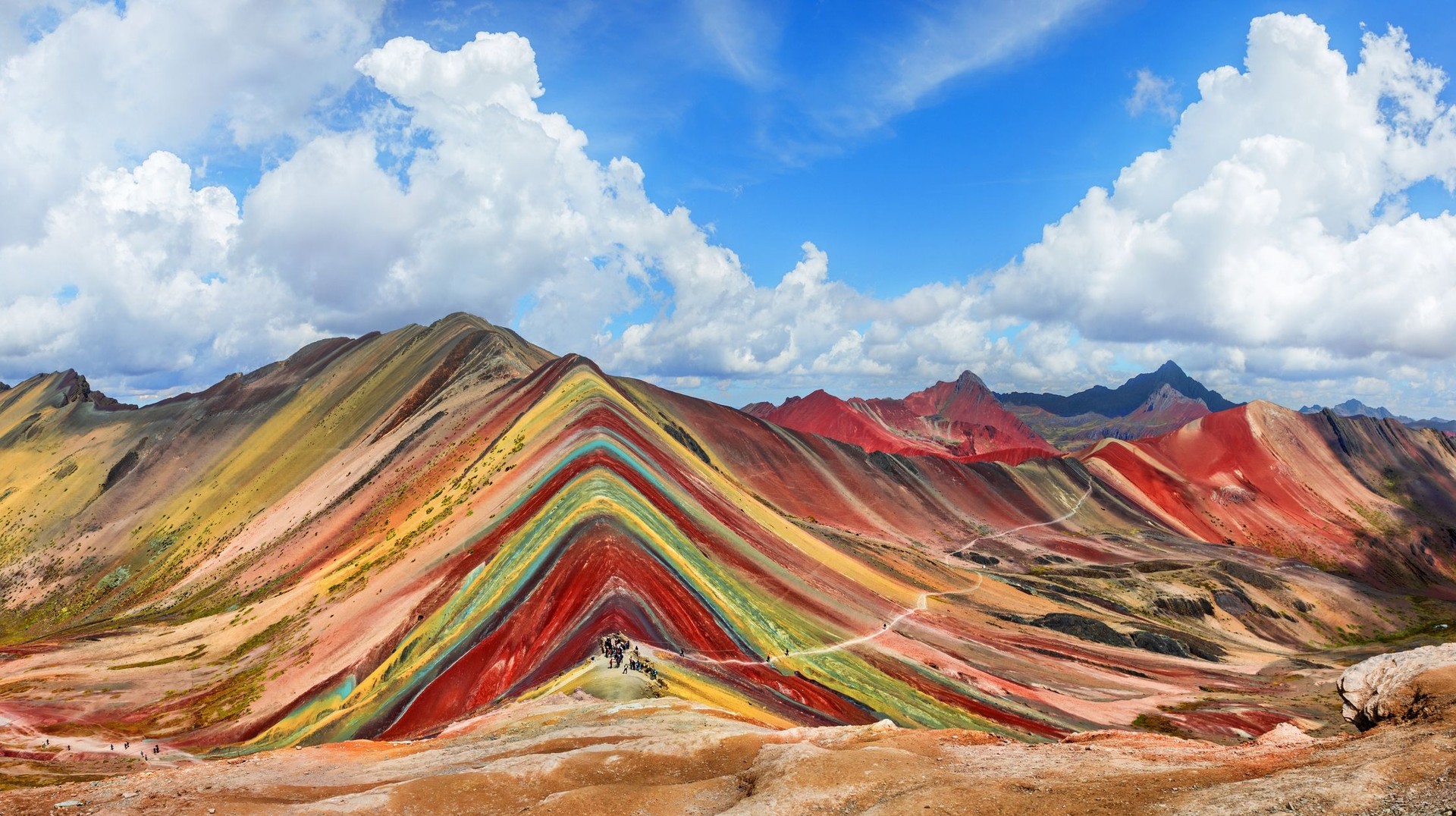 When spending 9 days in Peru, be sure to visit Cusco and hike its otherworldly Rainbow Mountain. Tourists hiking the Rainbow Mountain when spending 9 days in Peru.