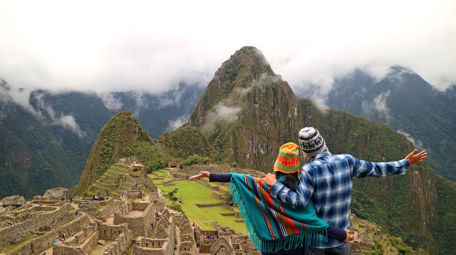 Couple admiring the spectacular view of Machu Picchu, Peru
