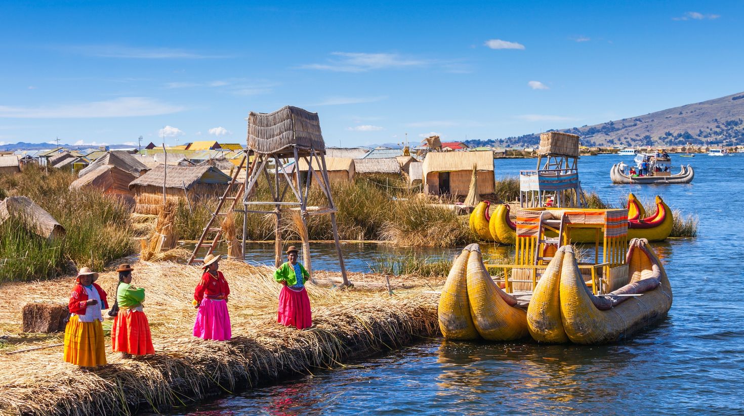 Unidentified women in traditional dresses welcome tourists in Uros Island.