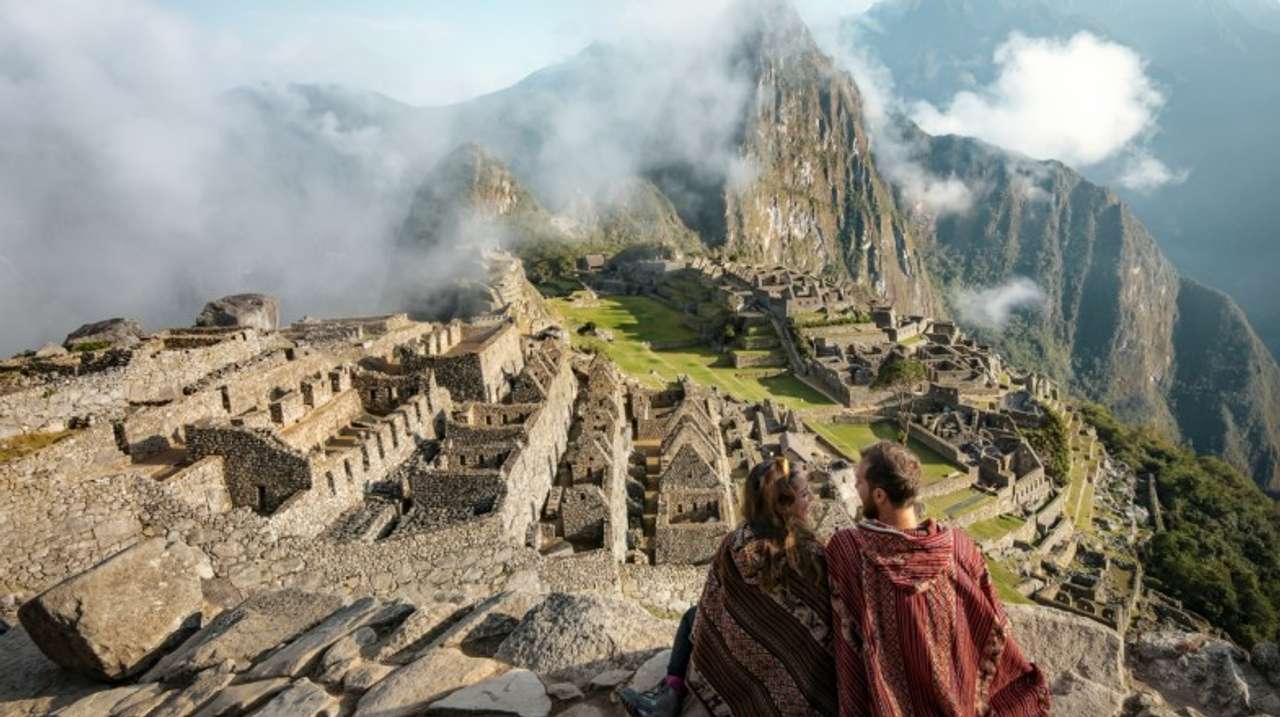 travelers taking in the sights of the ruins of Machu Picchu
