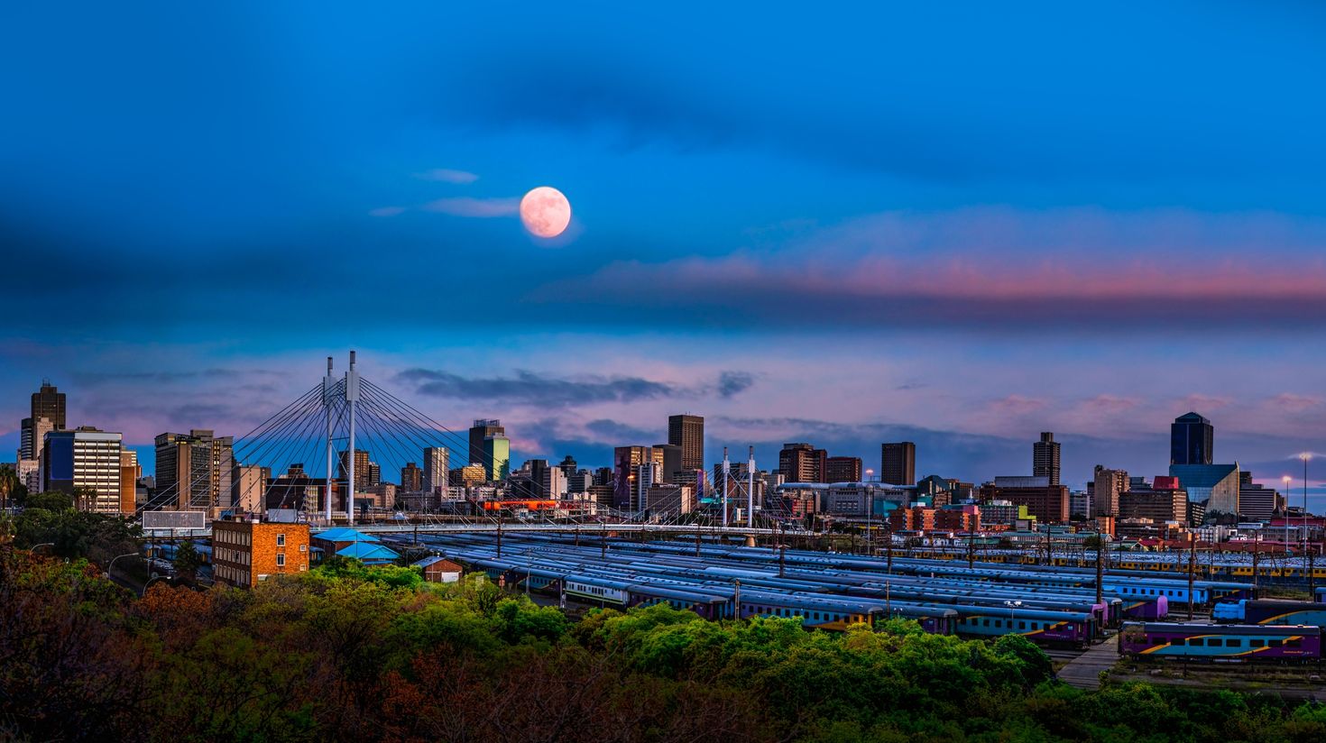 Johannesburg city skyline and Nelson Mandela bridge with moon in the sky