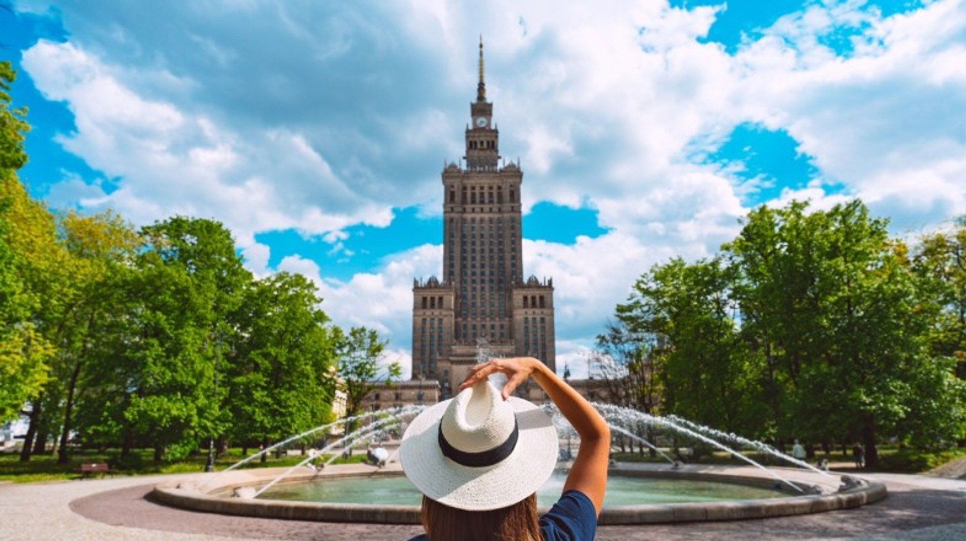 Discover the iconic Palace of Culture and Science in Warsaw, a must-visit landmark filled with history and breathtaking city views during your 6 days in Poland. A woman tourist in front of the Palace of Culture and Science in Warsaw during her 6 days in Poland.