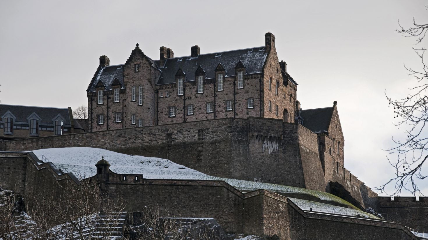 See the Edinburgh Castle covered in snow while visiting Scotland.