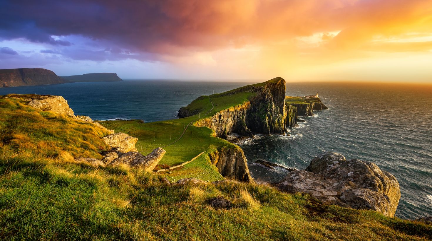 Colourful sunset at Neist Point lighthouse in Scotland in June.