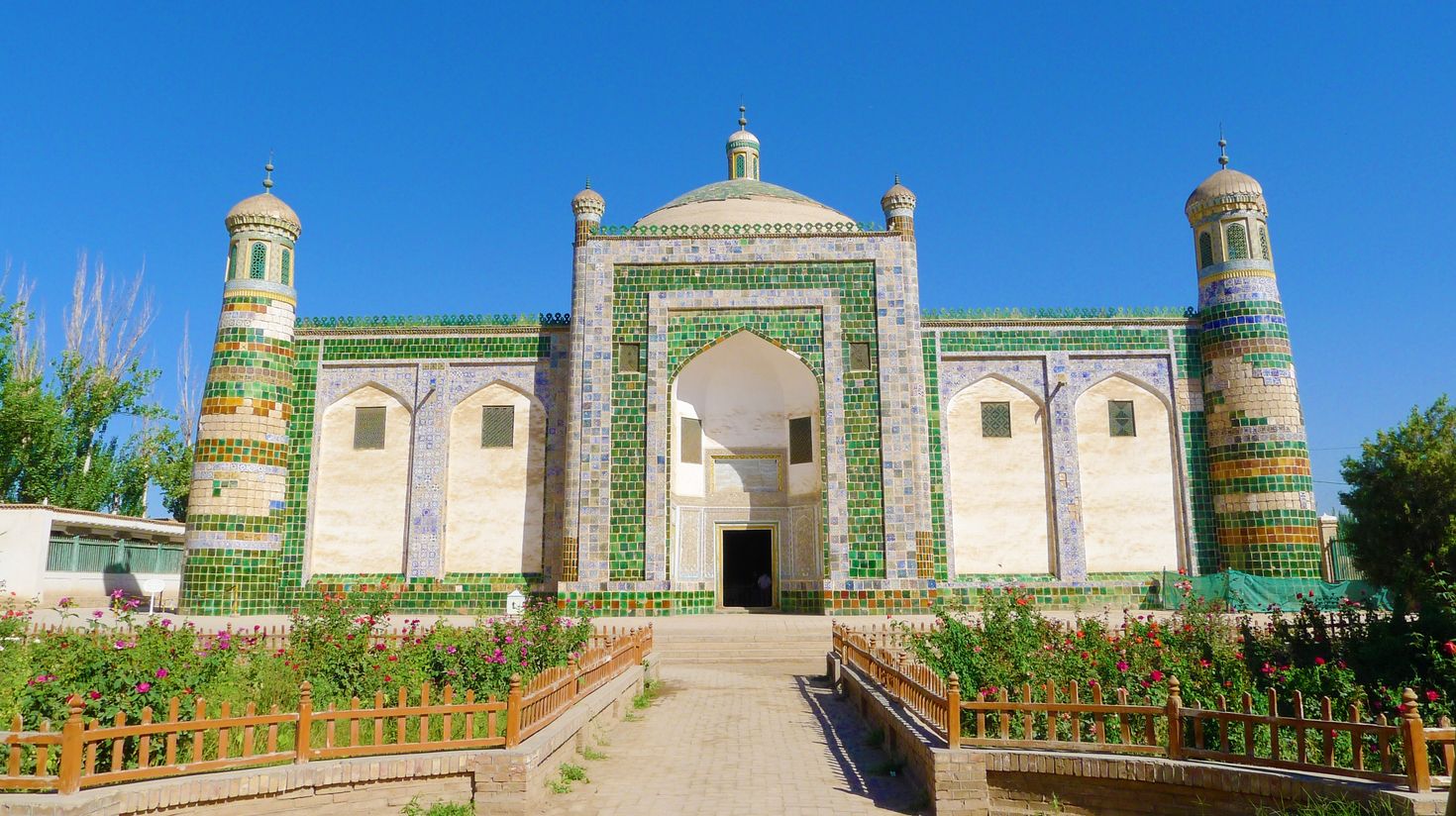 A front view of a Mausoleum building with small patches of garden