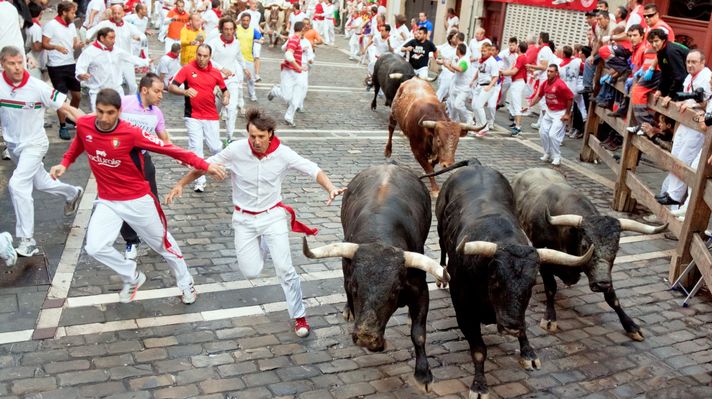 People run from bulls on street during San Fermin festival in Spain