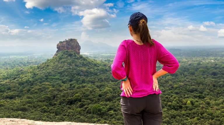 A tourist gazes at the ancient Lion's Rock in Sigiriya, Sri Lanka in May