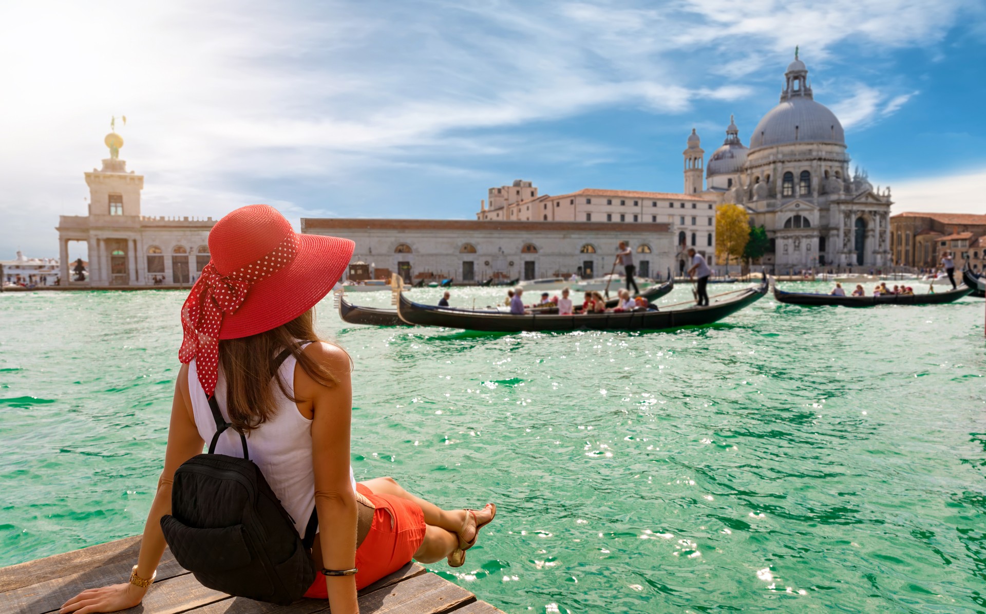 A female tourist looking at Salue and Grand Canal during summer in Italy.