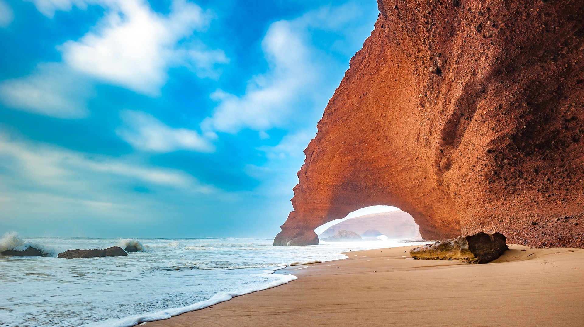 Relax and unwind on the beach while soaking up the sun during summer in Morocco. Red arch of Legzira beach during summer in Morocco.