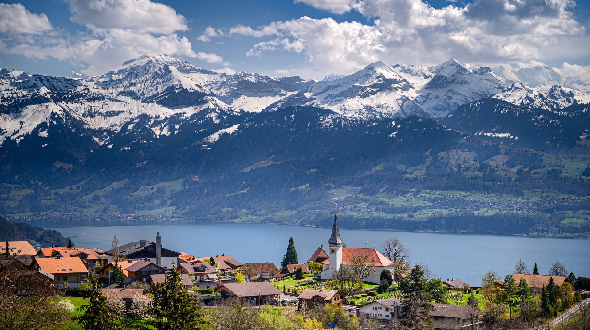 Visit bustling cities, go on adventurous hikes and take dreamy walks during a 7-day trip in Switzerland. Get this view of Lake Thun and mountain on a 7-day Swiss trip.