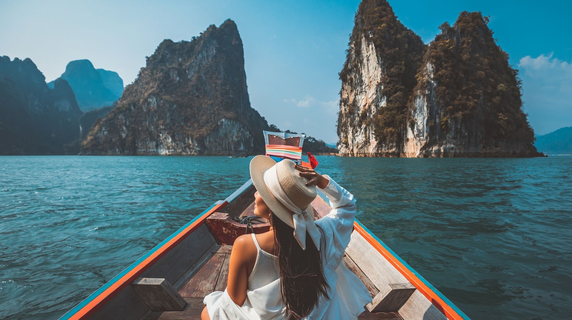 A tourist girl relaxes on a long-tail boat at Ratchaprapha Dam at Khao Sok National Park during her 2 weeks in Thailand.