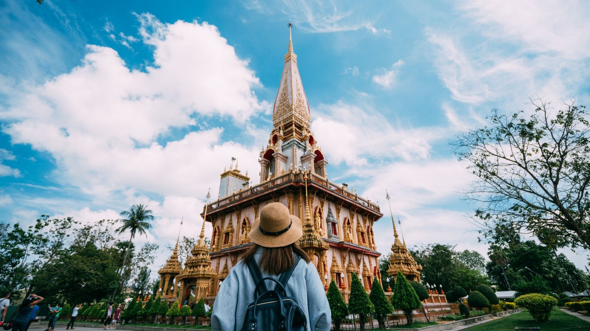 Immerse yourself in serenity and culture by visiting Wat Chalong Pagoda during your 4 days in Thailand and admire stunning architecture and peaceful surroundings. Young woman traveler with backpack admiring the beauty of Wat Chalong during her 4 days in Thailand trip.