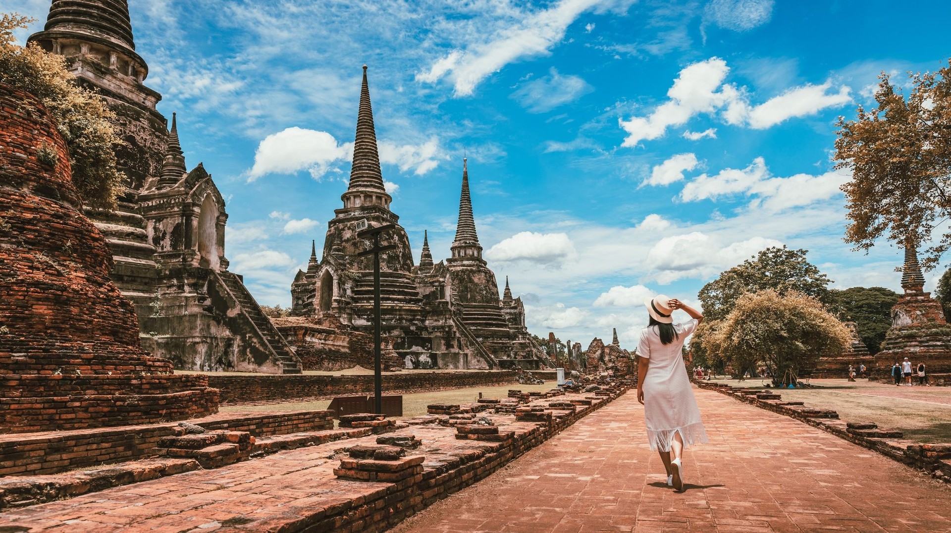 A tourist woman exploring Wat Phra Si Sanpet temple at Ayutthaya Historical Park on a cloudy day during her 9 days in Thailand.