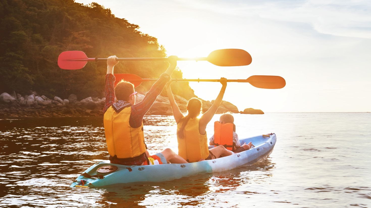 A family kayaking in the clear waters of Thailand