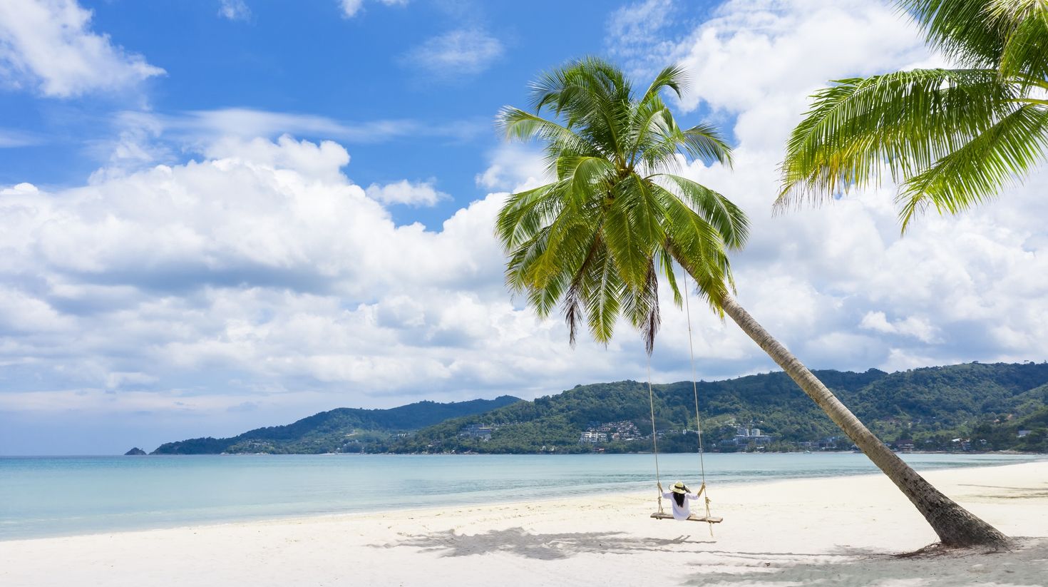 Tropical beach paradise with beach swing with girl in white shirt