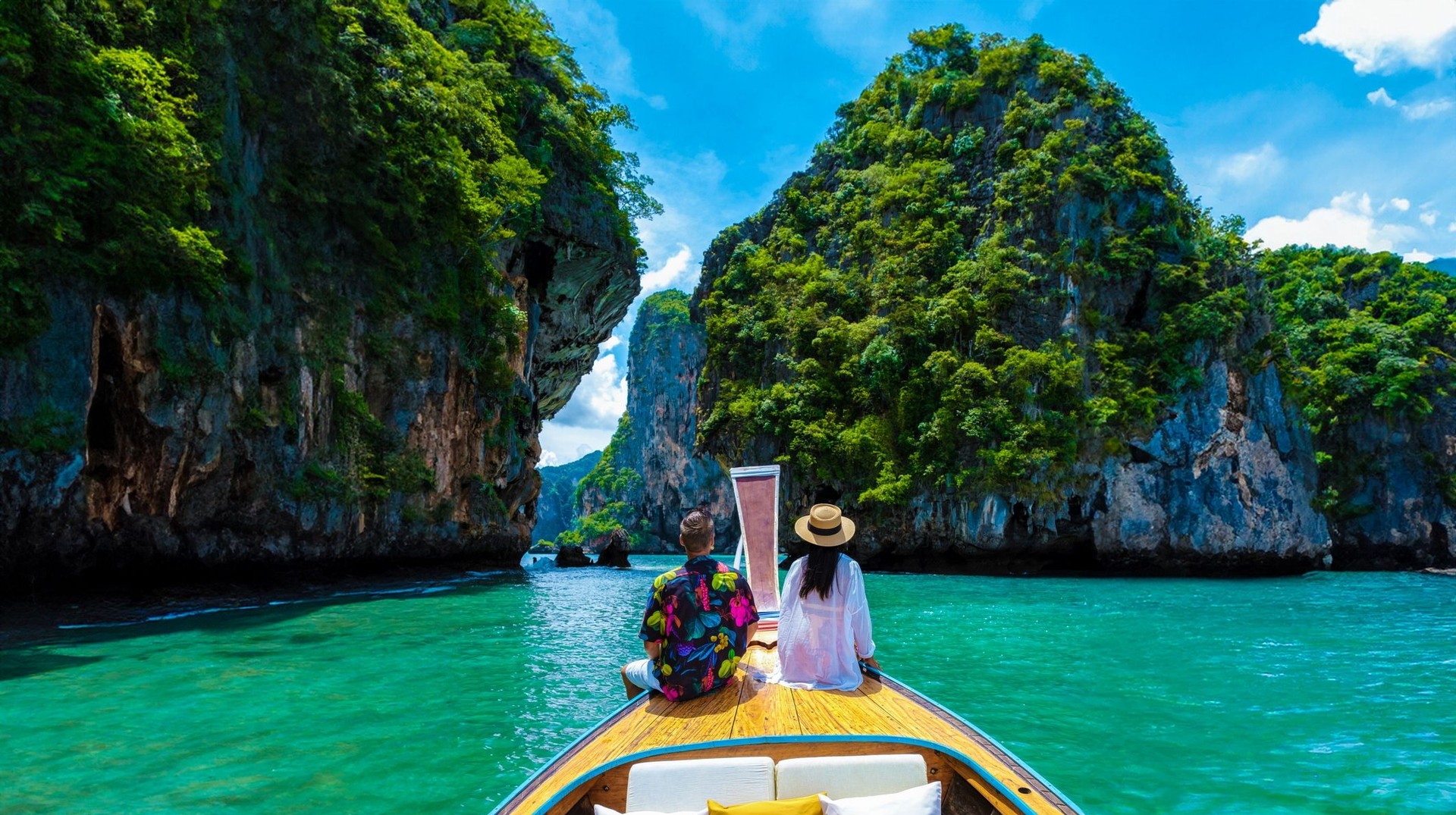 Experience paradise during your one week in Thailand by soaking up the sun and beauty of Krabi Island, where every day is a perfect escape. A couple in the long-tail boat enjoying the view of Krabi island during their one week in Thailand.