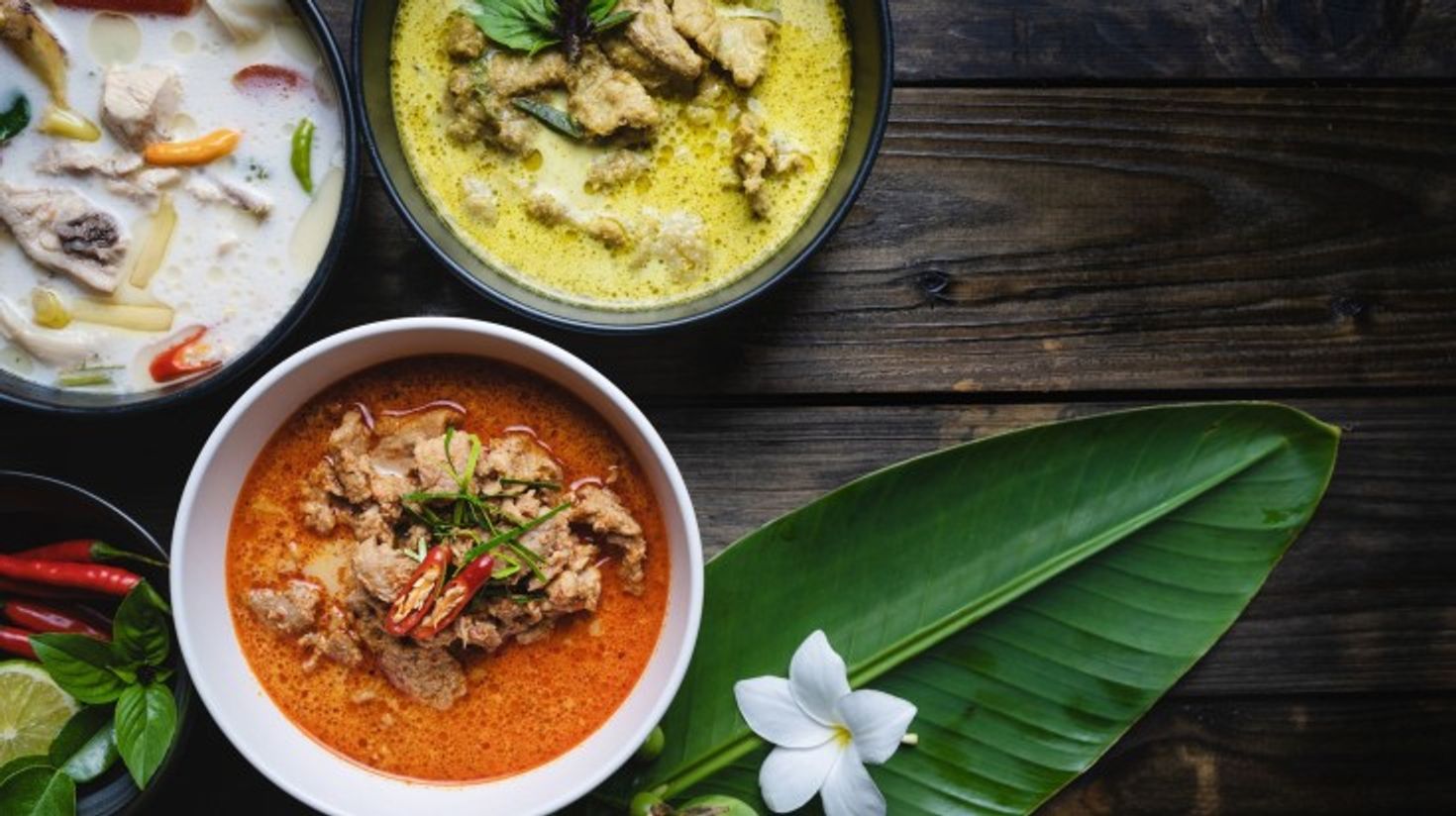 Top view of Panang, Kaeng Keaw Whan and Tom Kha Gai served on a table.