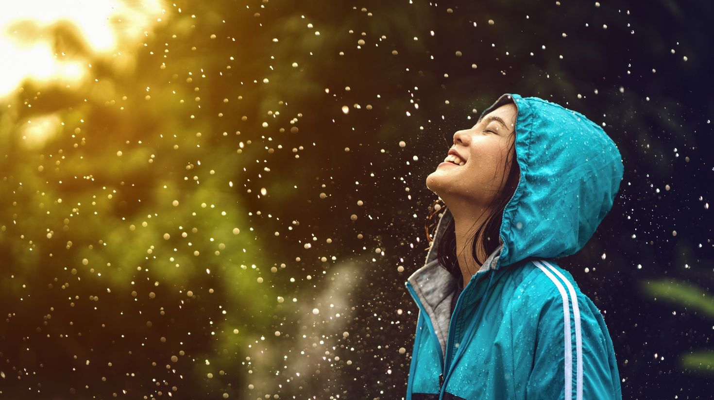 A girl enjoying the rain in Thailand during September.