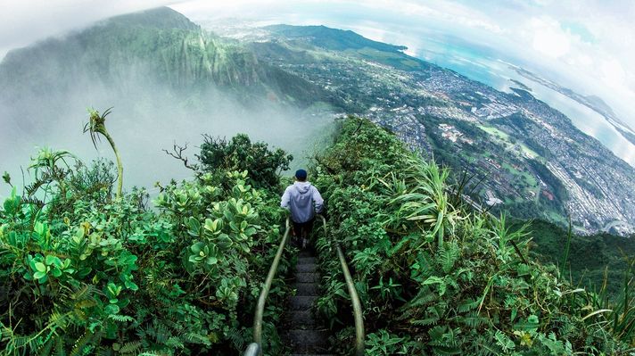 A man on the hills of Oahu, surrounded by sea in USA